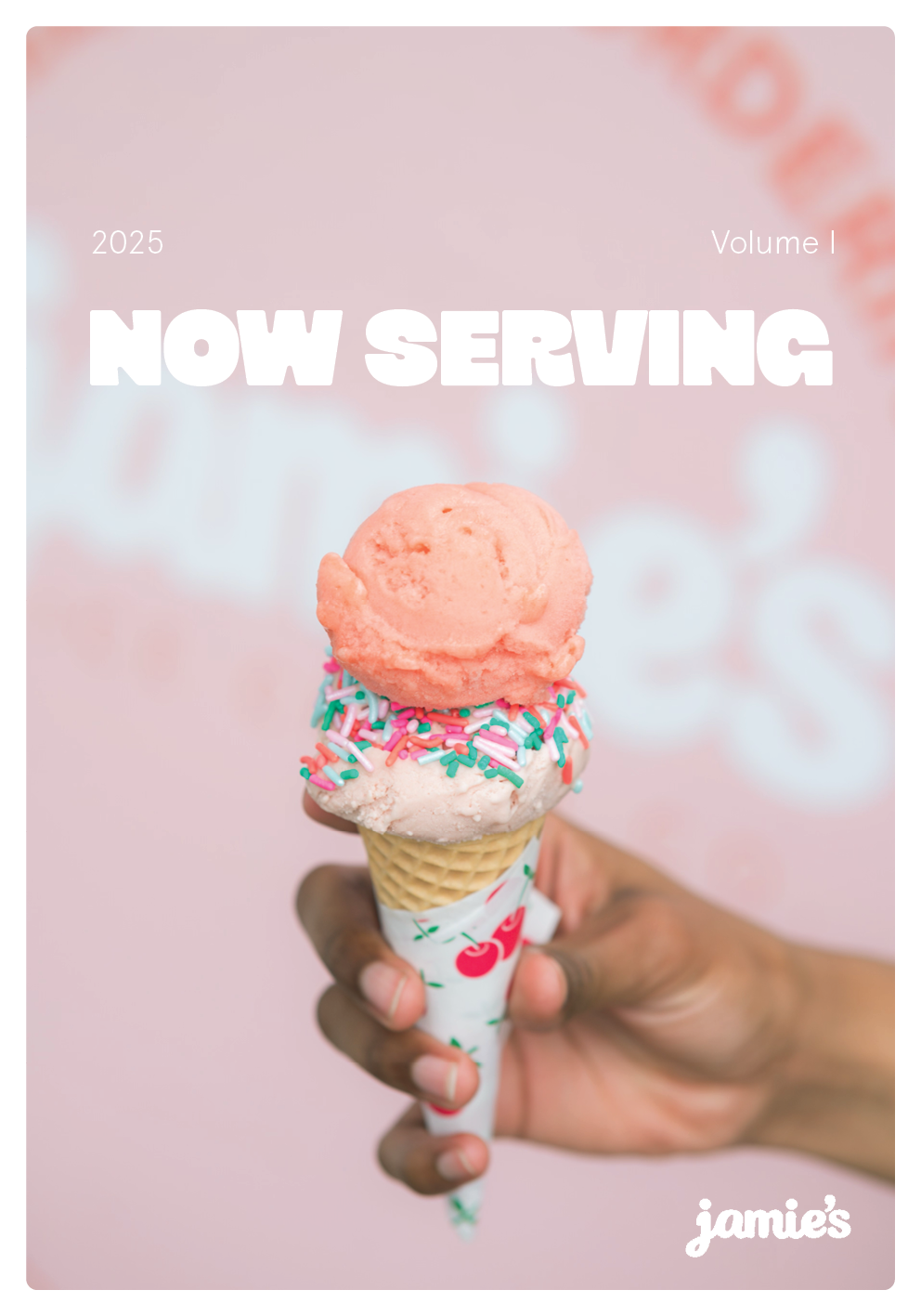 A hand holding an ice cream cone with two scoops, pink and white, topped with colorful sprinkles against a pink background with blurred text.