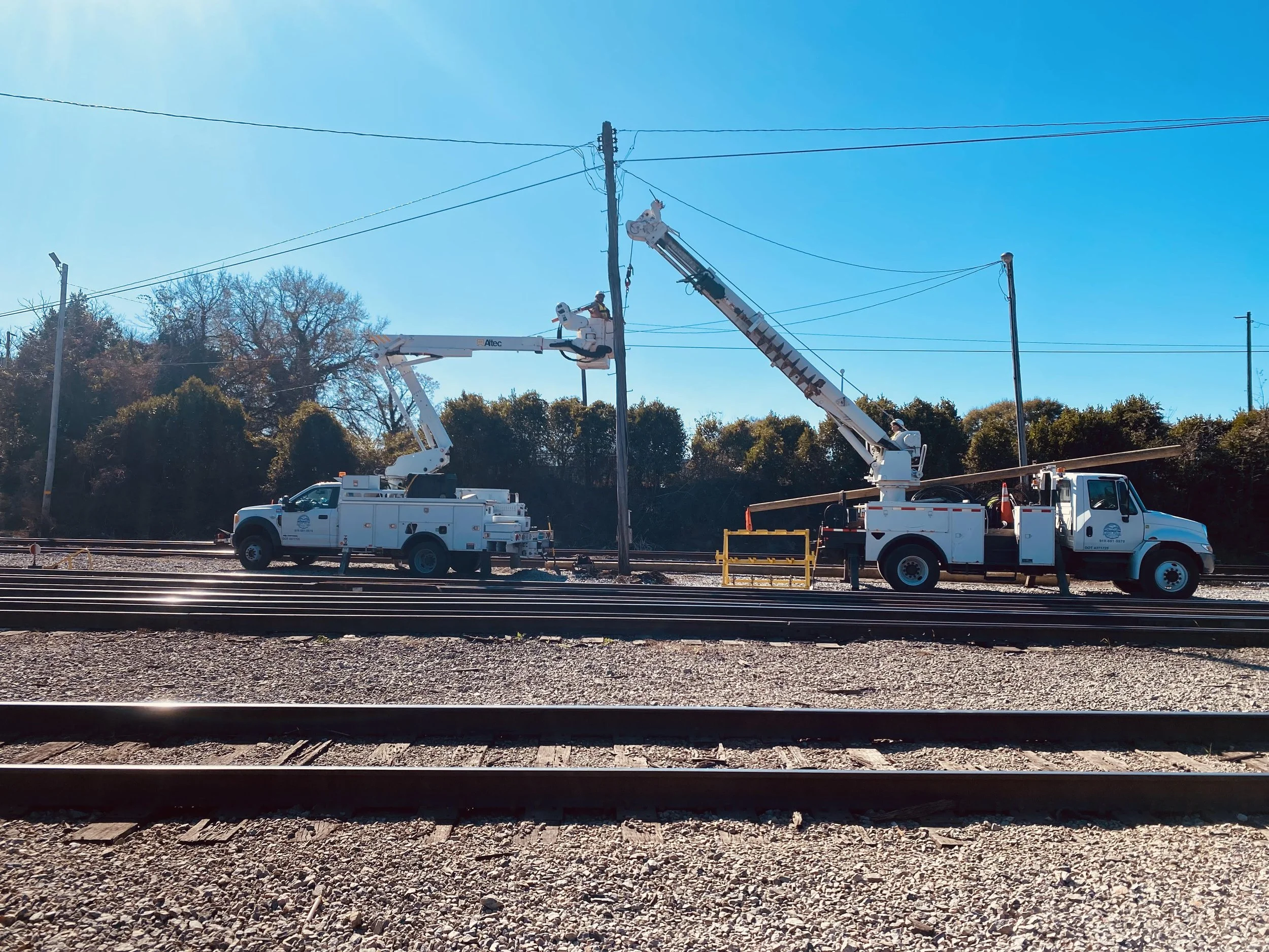 Two people removing and replacing a utility pole for Light, Pole and Services LLC