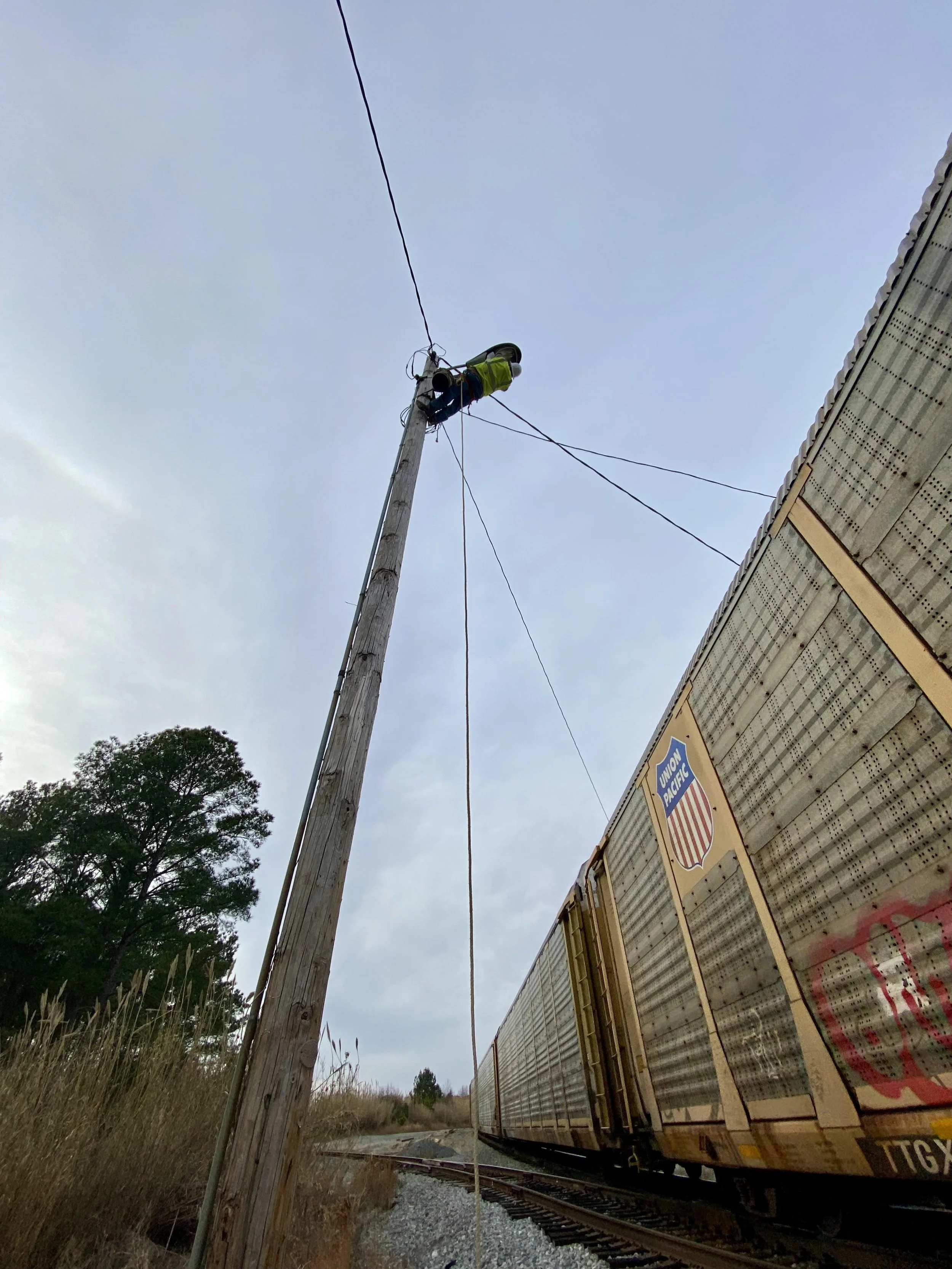 A lineman climbing a pole to fix a light for Light, Pole and Services LLC