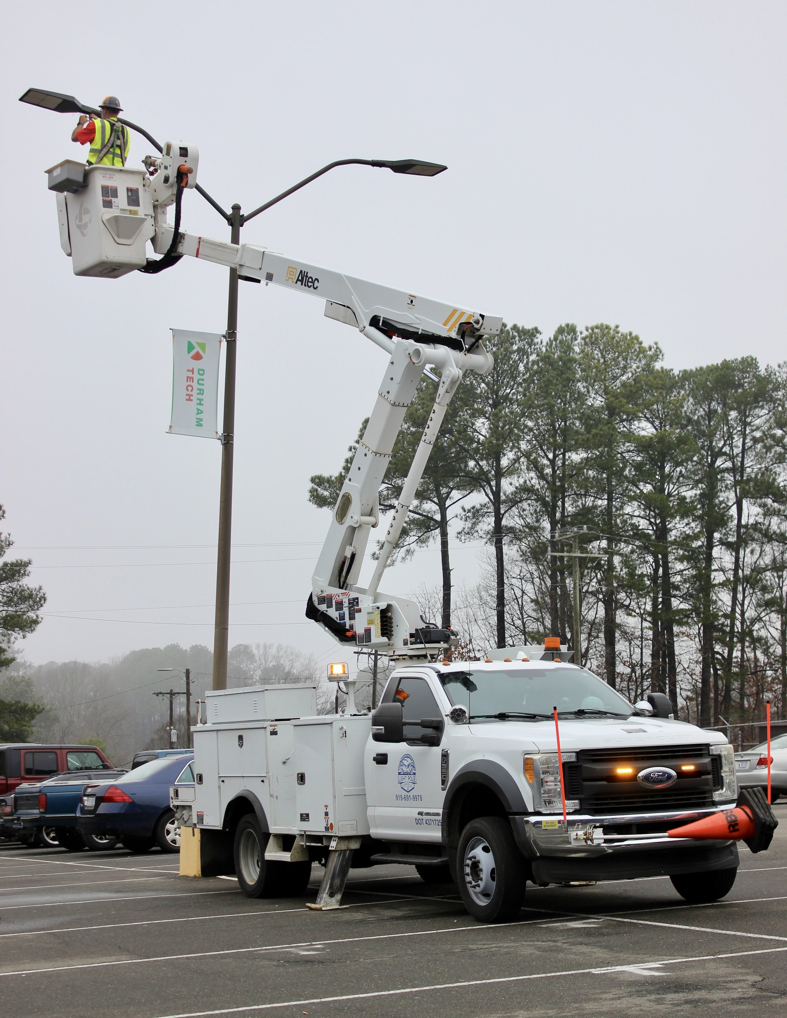 Electrician in bucket truck install LED lights