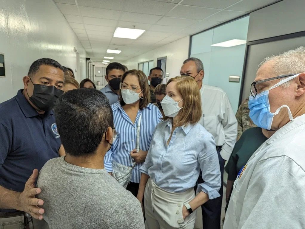 Group of people wearing face masks talking in a hallway