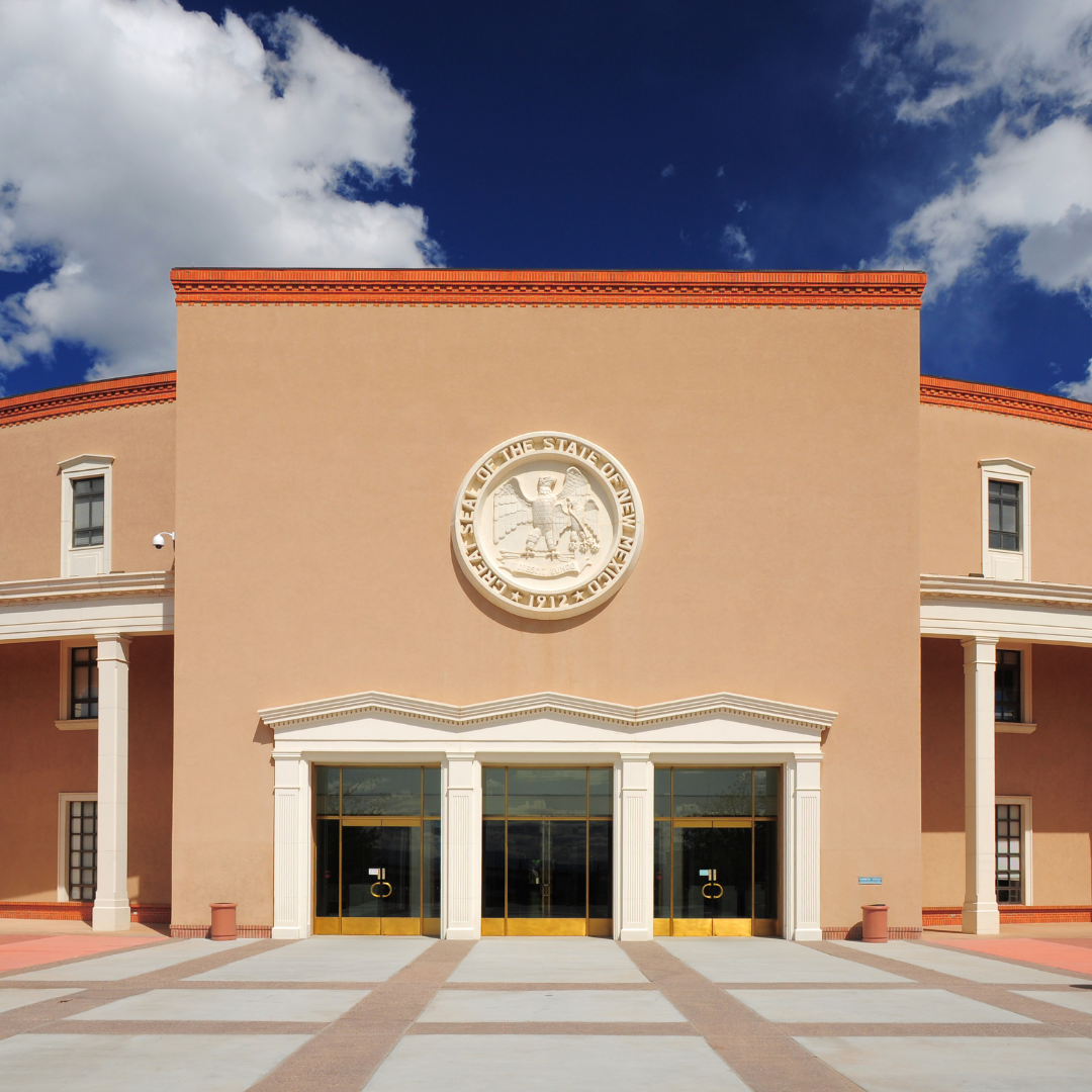 Front view of New Mexico State Capitol building with state seal, clear sky