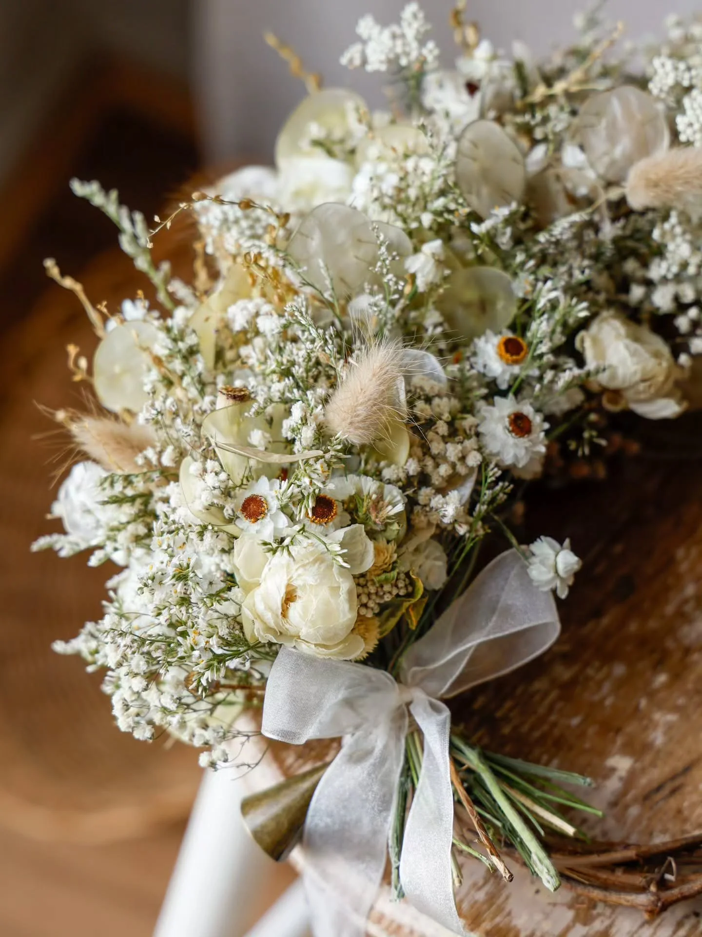 She is named 𝒪𝓅𝒶𝓁𝒾𝓃𝑒 𝒲𝒽𝒾𝓈𝓅𝑒𝓇 for her gentle presence and the quiet, floral magic she brings to Christmas.

Winged daisies, ranunculus, and bunny tails are woven onto a foraged grapevine base, with luminous honesty pods lending her that 