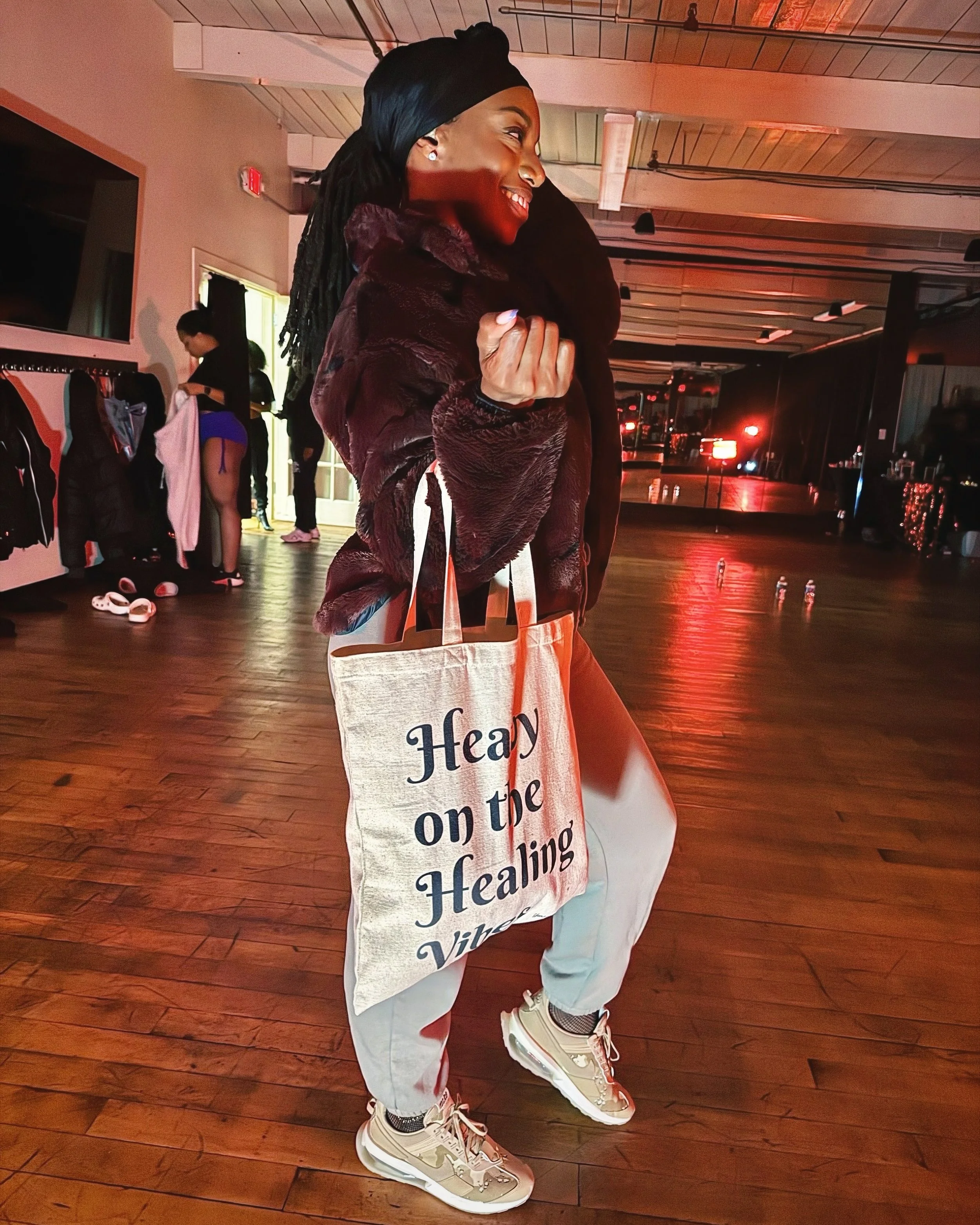 A woman holding the Healing Vibes Tote Bag, showcasing its minimalist design and durable eco-friendly canvas for wellness, self-care, and daily essentials.