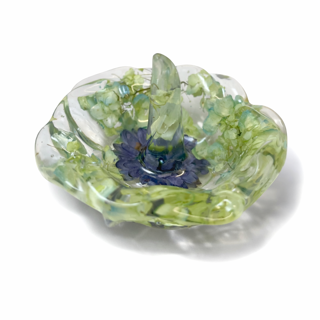 Glass art bowl with green, blue, and clear swirls, shaped like a flower.