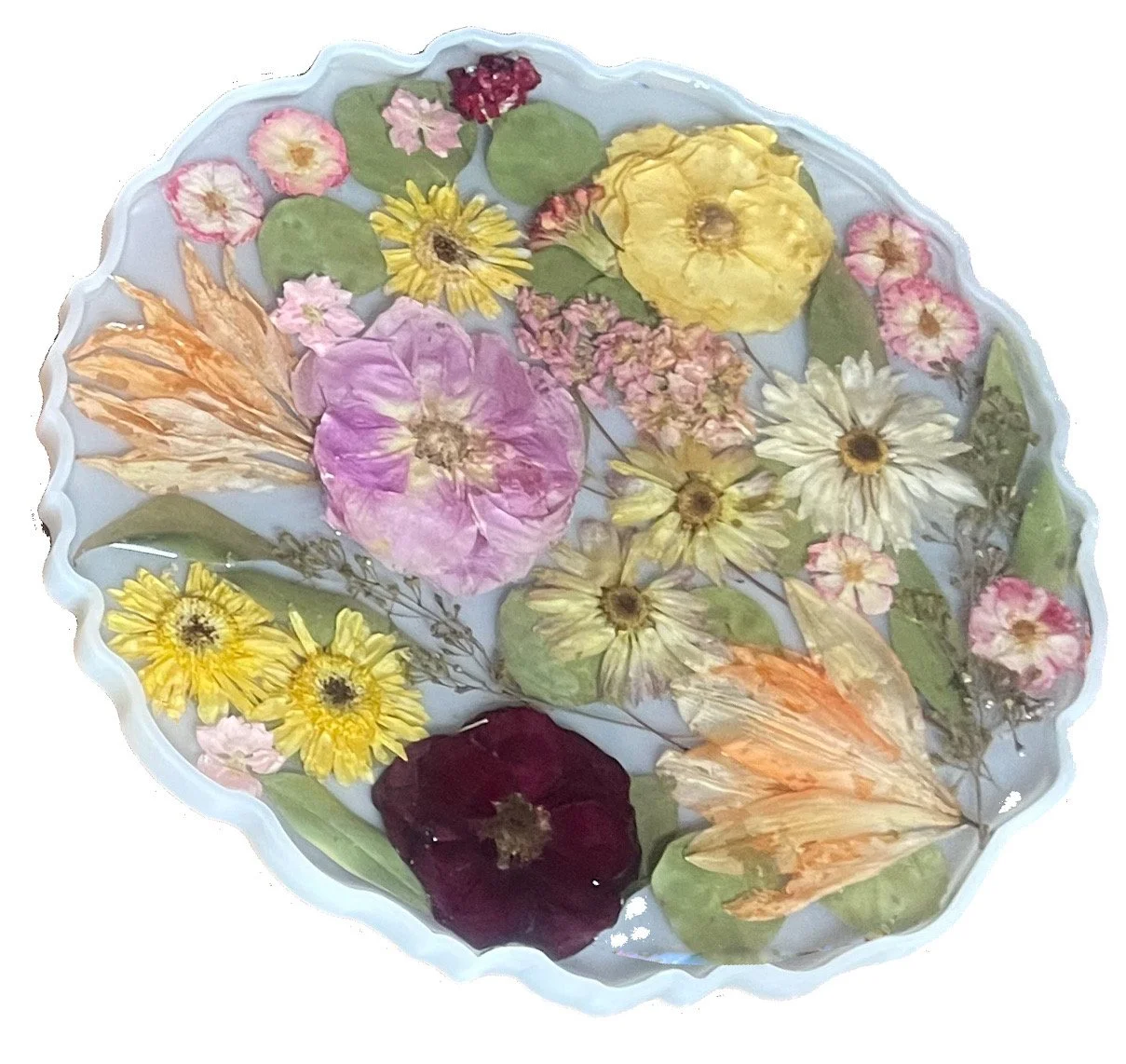 A decorative ceramic bowl filled with various dried pressed flowers and leaves, some with vibrant colors like purple, yellow, red, pink, and white.