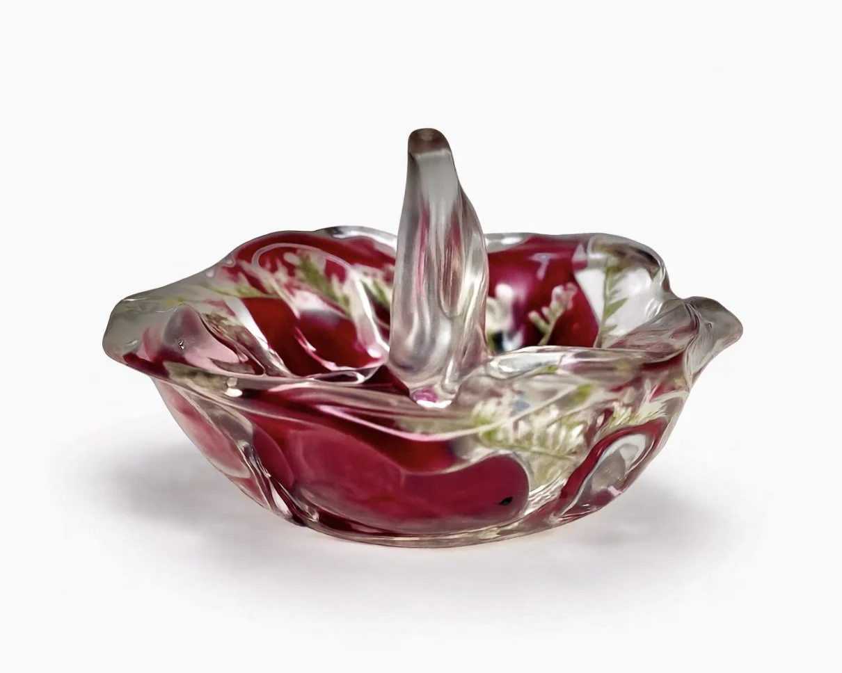 Decorative glass bowl with red and green swirl design on a white background.