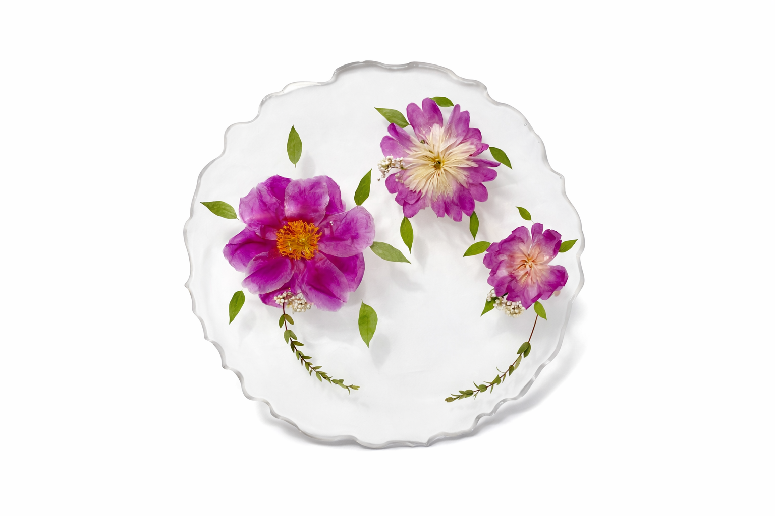 A round glass plate with a scalloped edge, decorated with pink and purple flowers and green leaves.