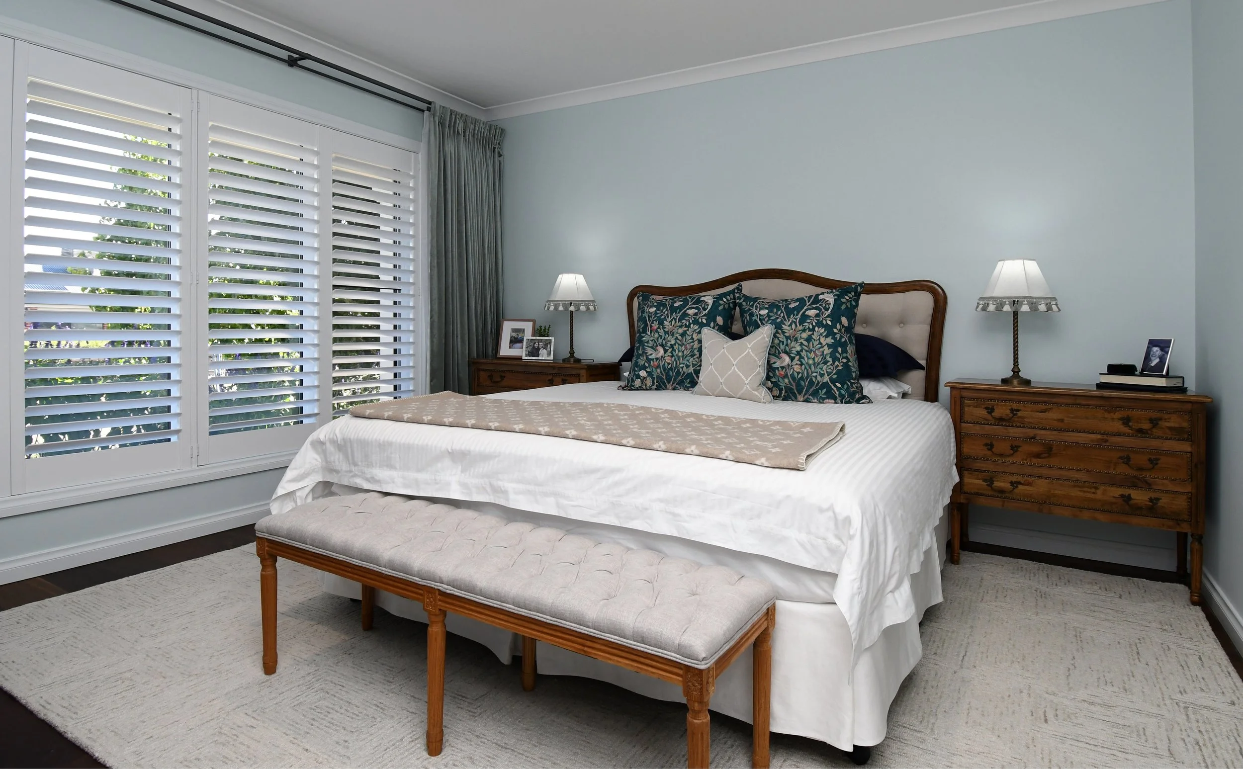 Cloudview master bedroom view from the foot of the bed towards the head with the French oak suite, cream satin stripe bedspread and William Morris pillows in shades of teal, duck egg blue and sage green.