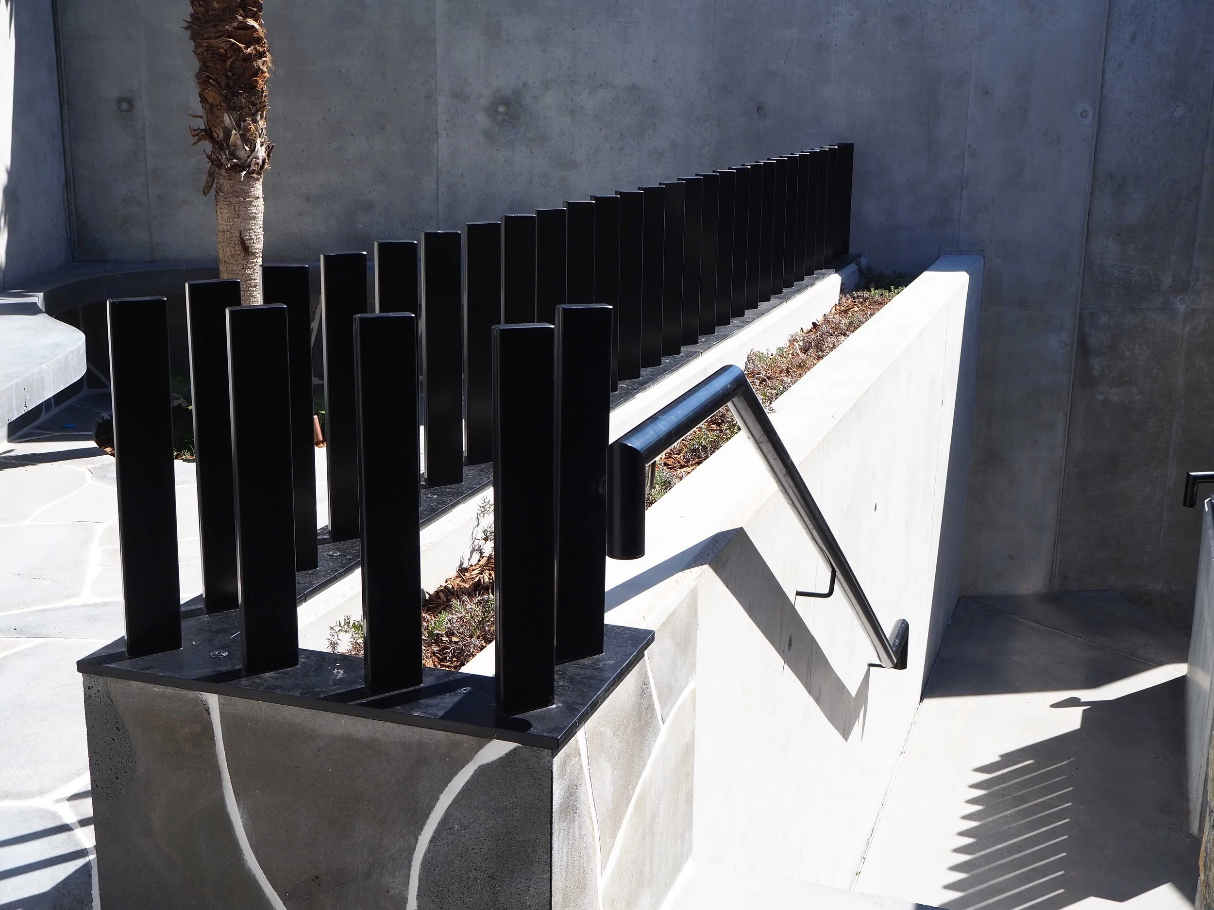 black metal handrail with low barrier fence vertical fins.jpg