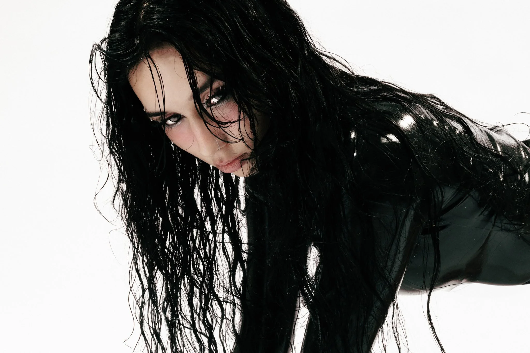 Cinematic alternative portrait of a woman with long wet dark hair in black latex, shot by LA music photographer Lea The Wise