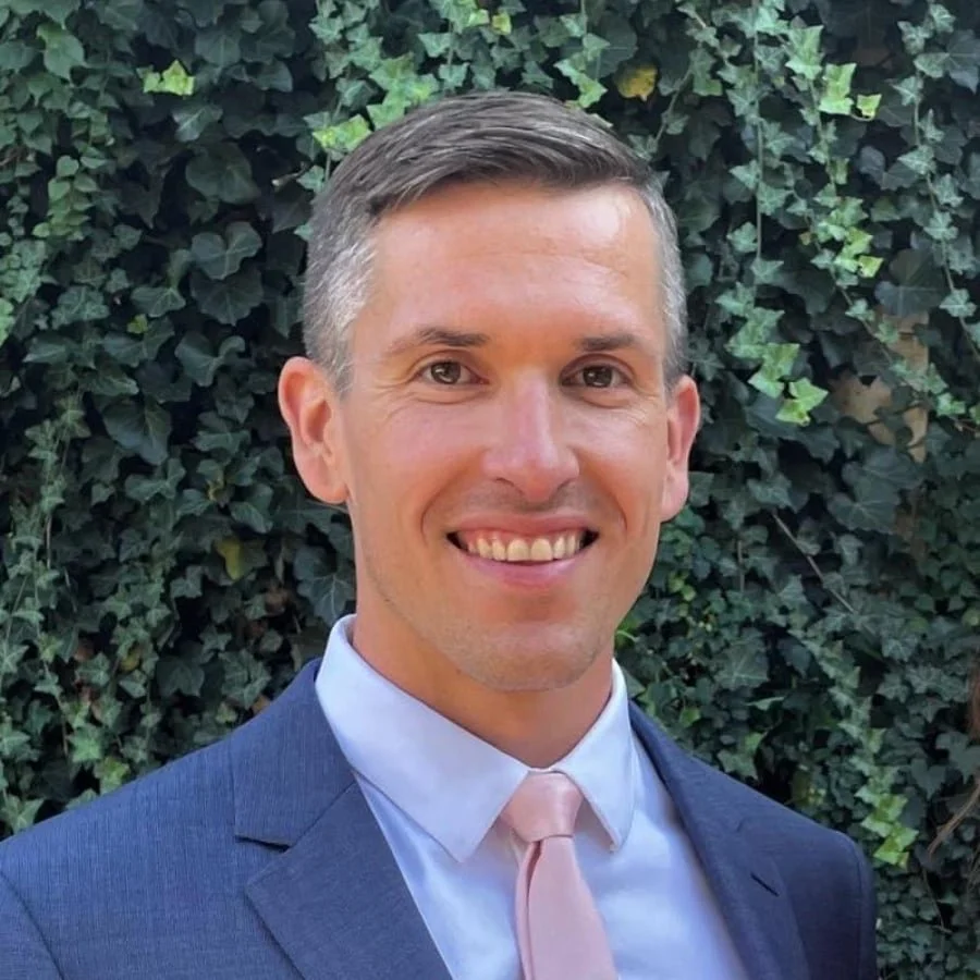 Man in blue suit, blut shirt and pink tie