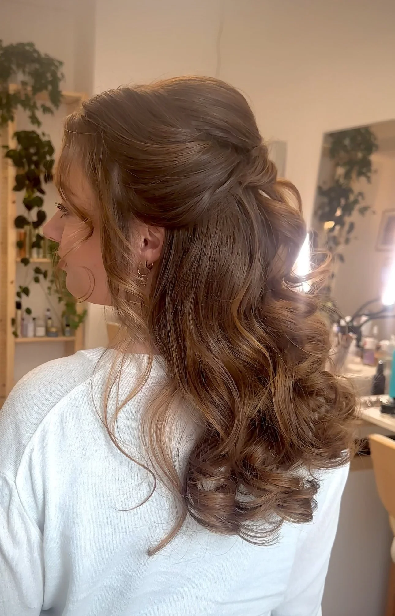 Karamellbraune Brautfrisur mit lockigem Haar in einem Salon.