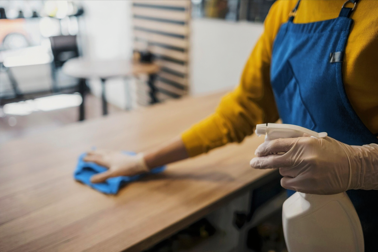Startbild: Person putzt Tisch