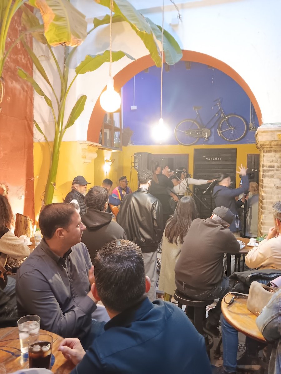 Patrons watching a live music performance in a crowded bar