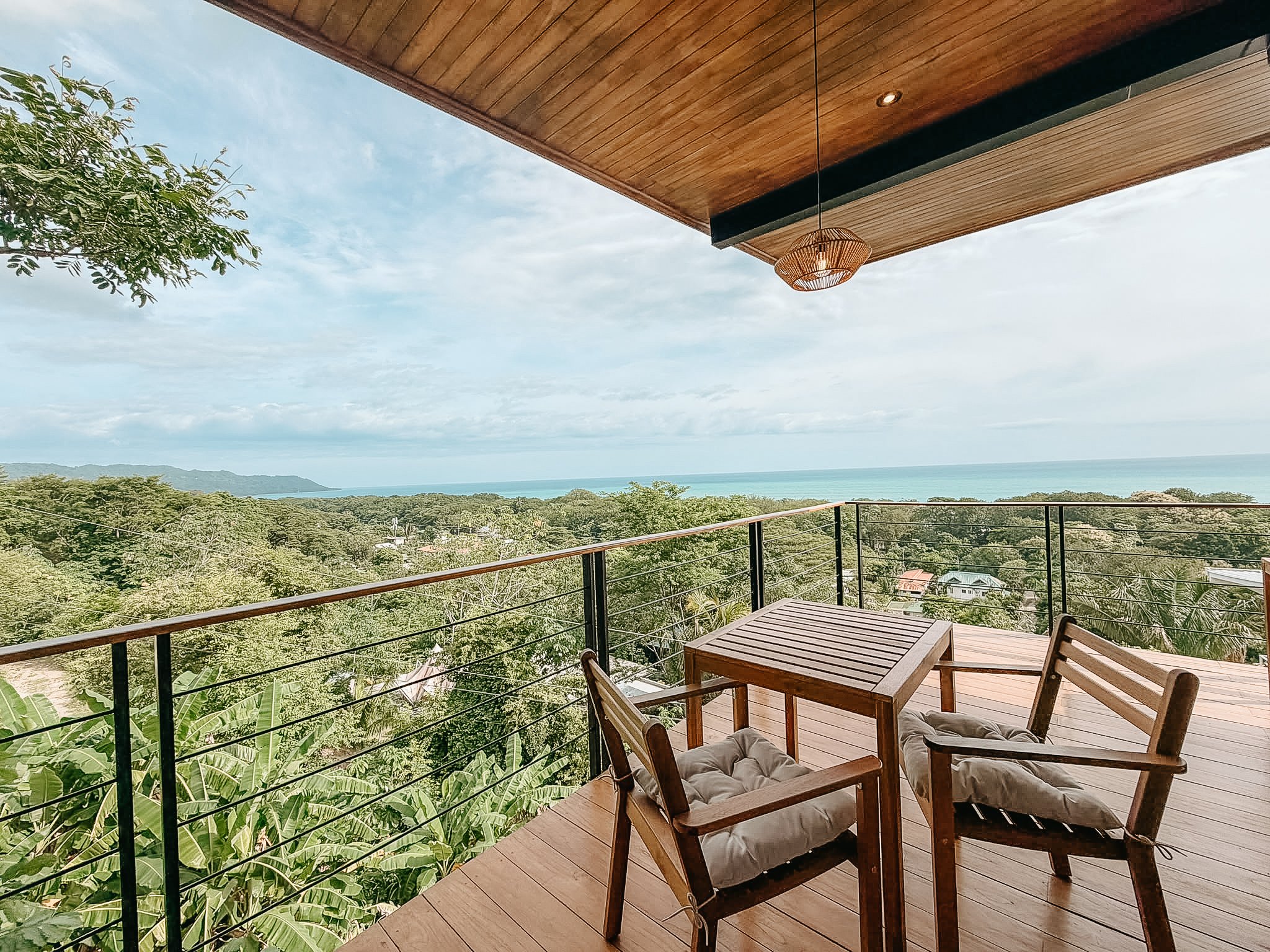 Private balcony at Casa Surya overlooking the tropical landscape and Pacific Ocean.