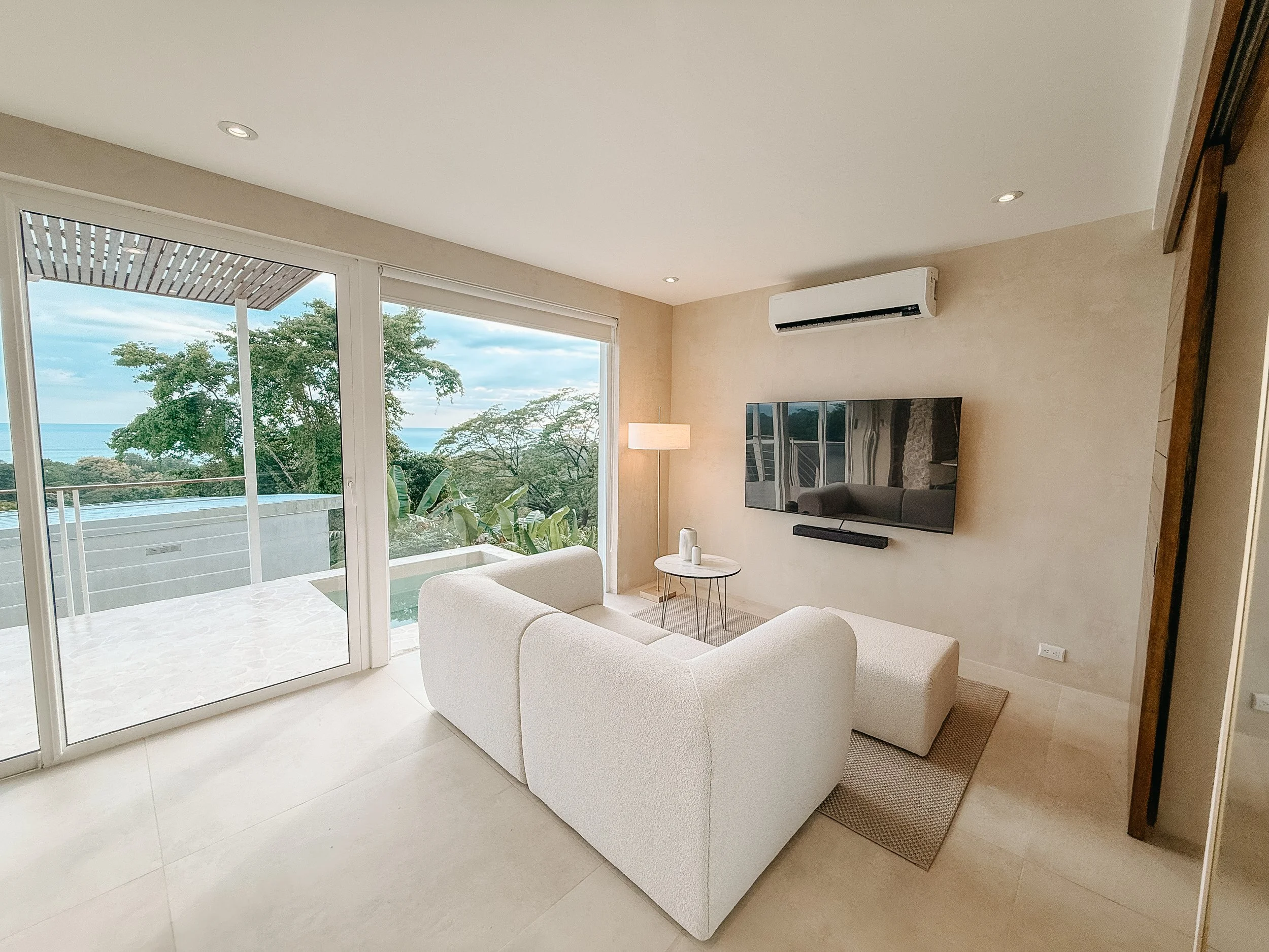 Casa Cueva living room with smart TV, floor-to-ceiling windows and views of the private plunge pool and ocean.