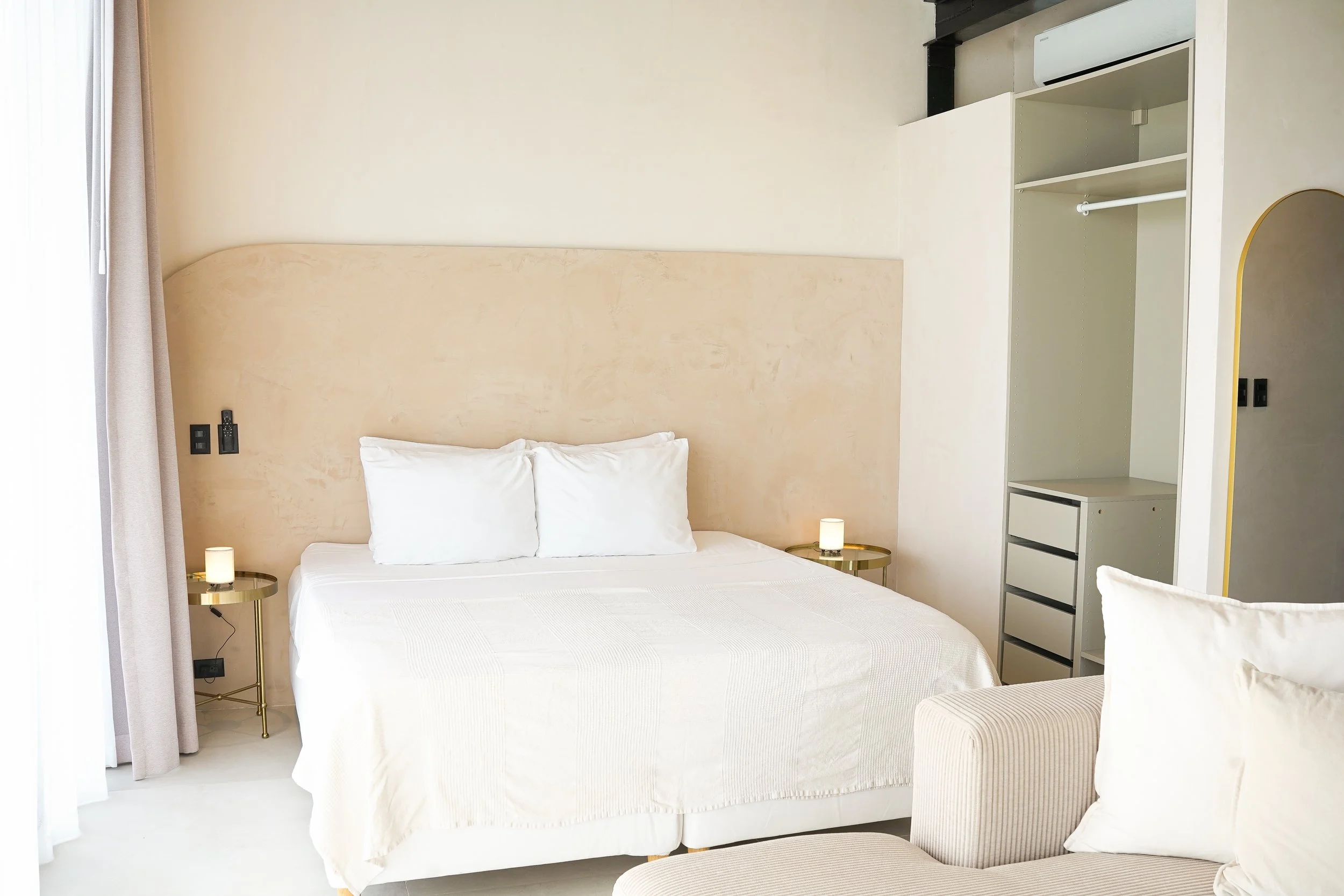 Casa Surya ocean-view studio with king-size bed, lounge chair, soft curtains and warm natural textures