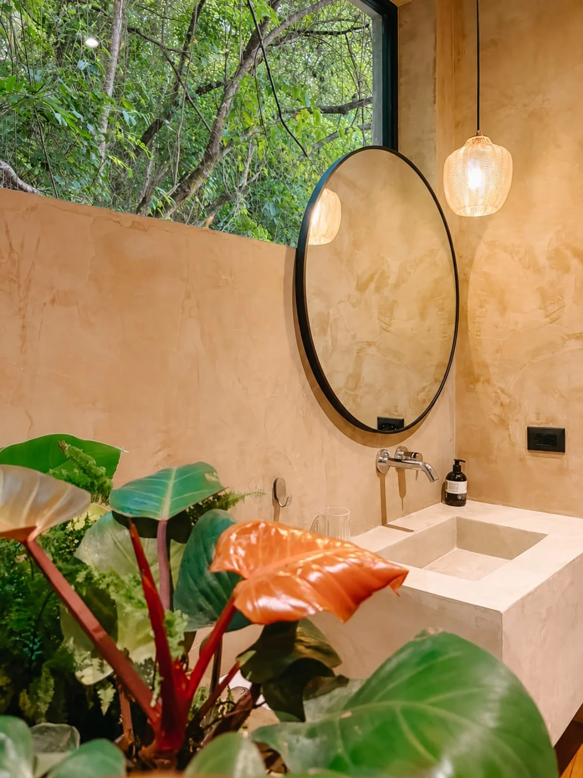Bathroom with a concrete sink and a private jungle view.