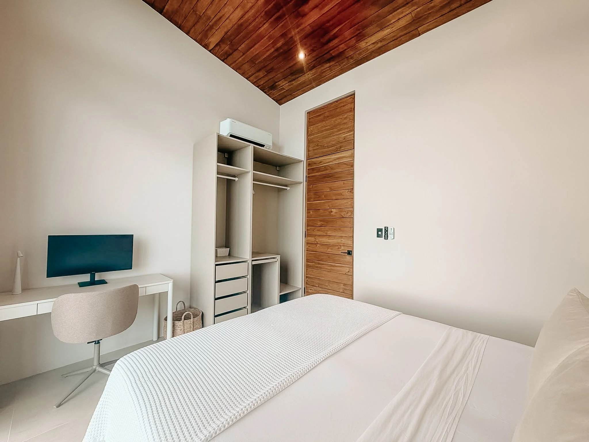 Second bedroom at Villa Nalu with a king-size bed, dedicated workspace and open wardrobe.