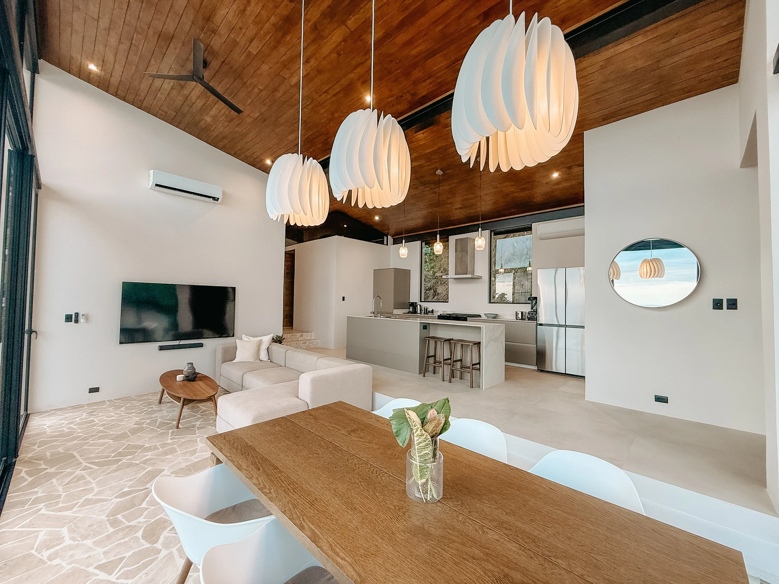 Open-plan Villa Nalu interior combining the living room, dining area and fully equipped kitchen.