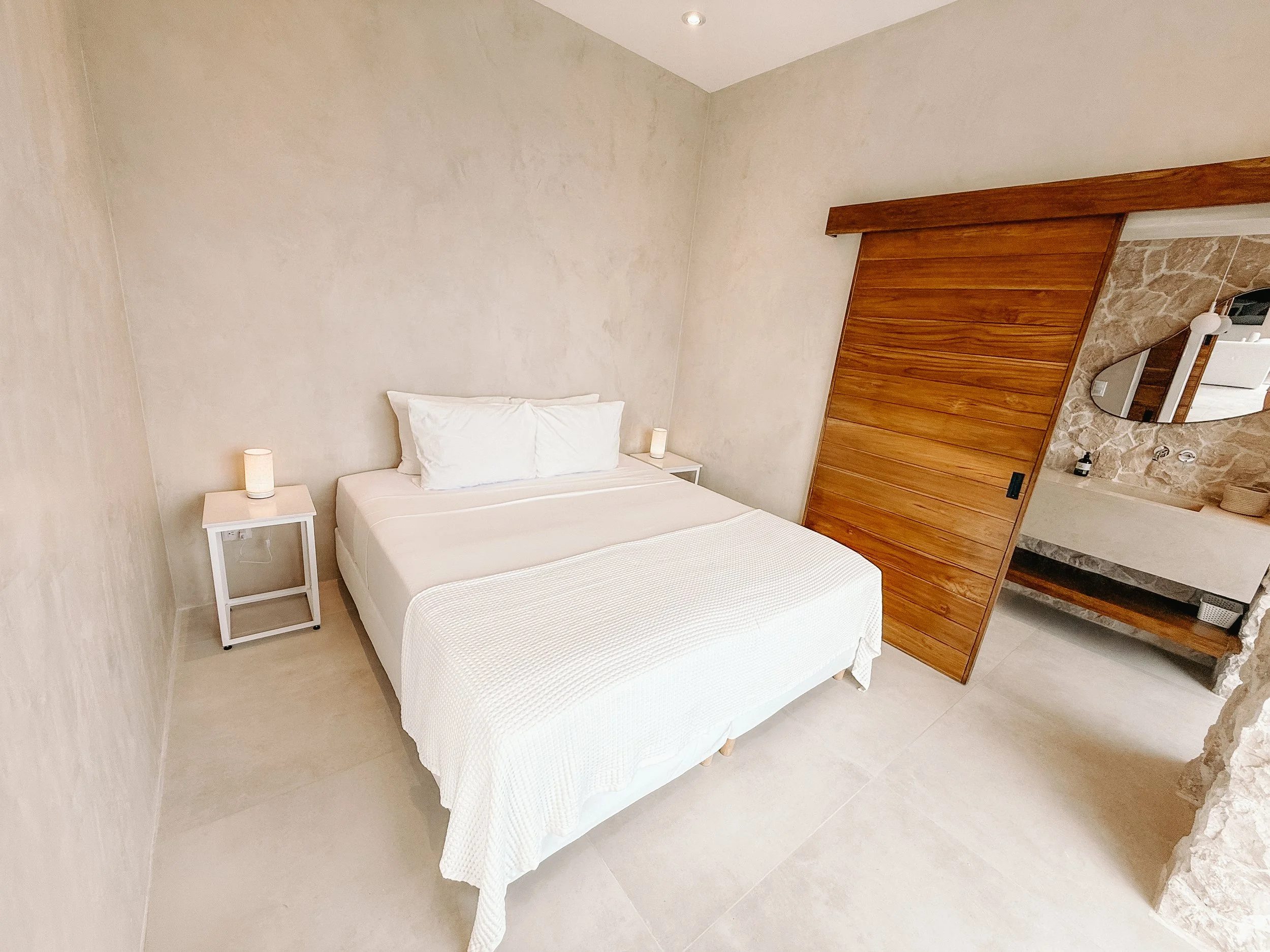 Bright second bedroom at Casa Cueva with warm wood details and an ensuite bathroom.