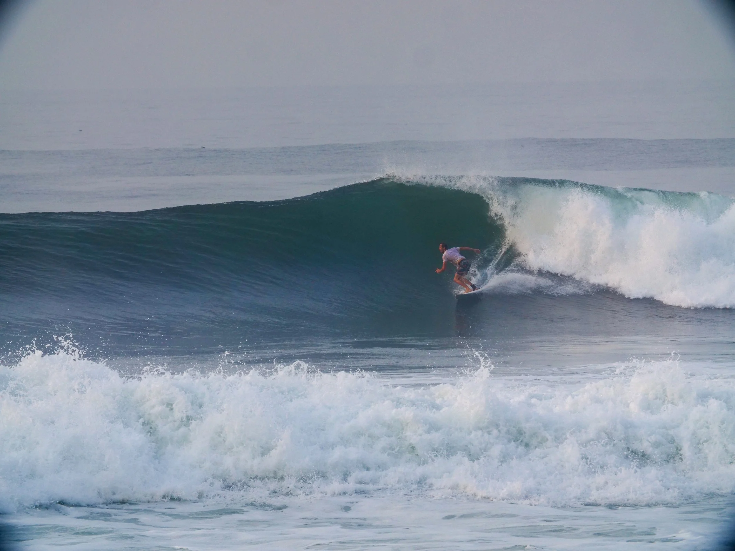 Surfer riding a wave in Santa Teresa, Costa Rica.