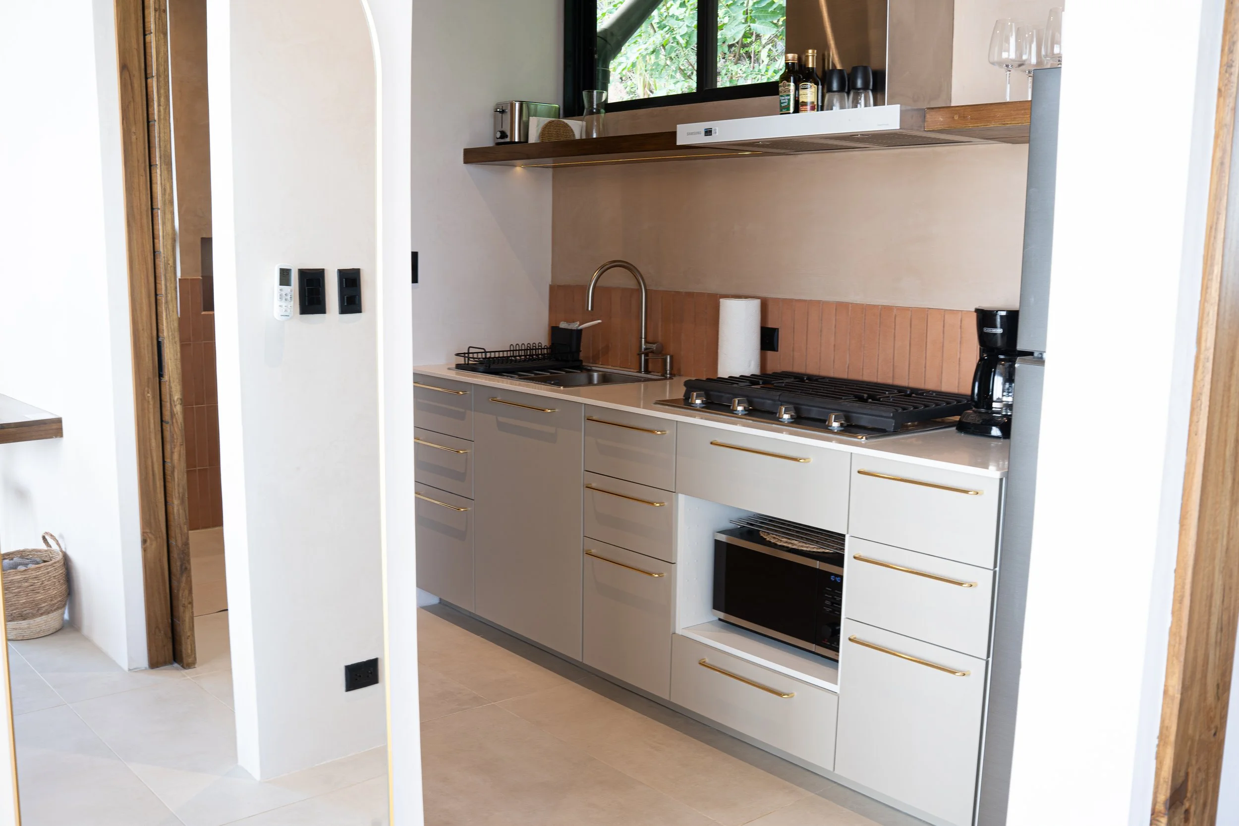 Fully equipped kitchen at Casa Surya with gas stove, coffee machine and warm natural materials at VISTA NALU.