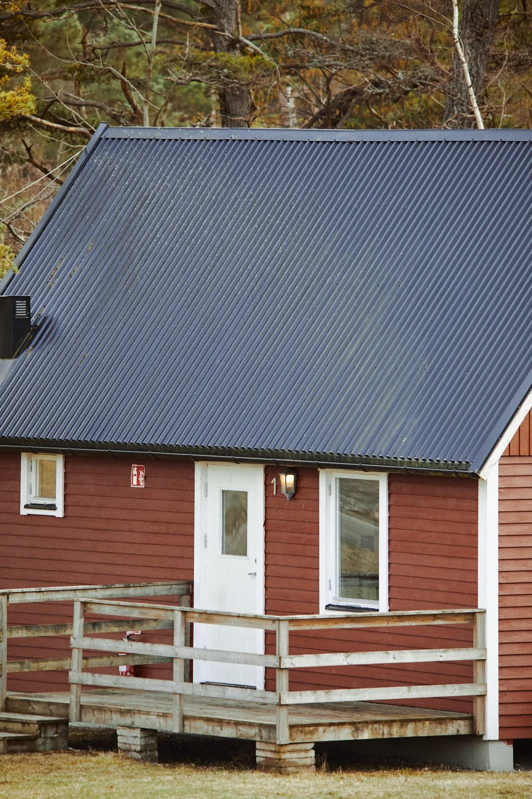 Small red cabin with a metal roof and wooden porch in a forested area.
stugor eller stuga på gotland kom och bo hos oss i lugna valleviken på norra gotland i Rute