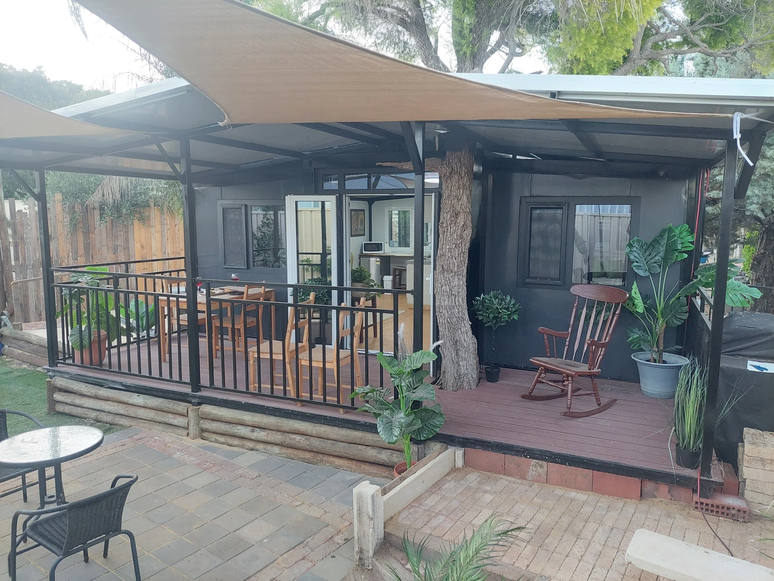 Modern expandable container home at night with warm interior lighting