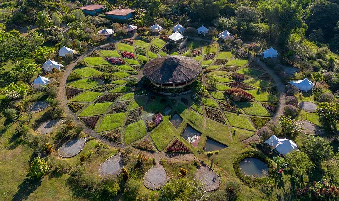 Two people examining colorful, intricately patterned textile art and beadwork.