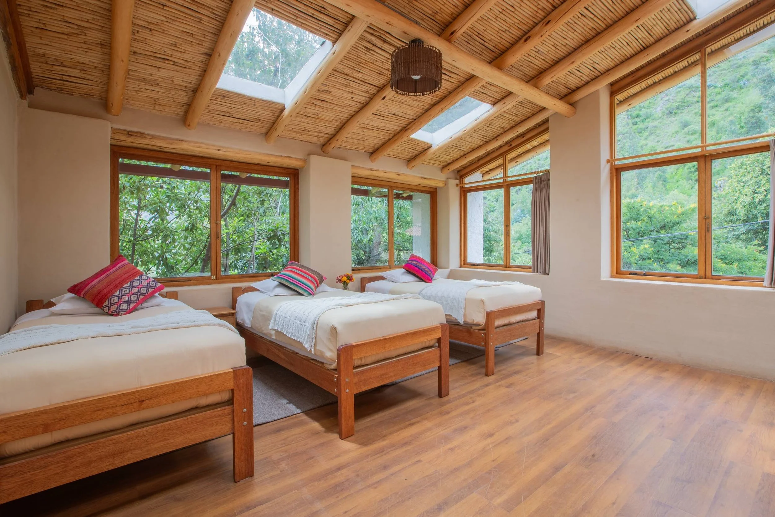 A woman pouring water over a shirtless man sitting on a chair outdoors, surrounded by lush green plants.