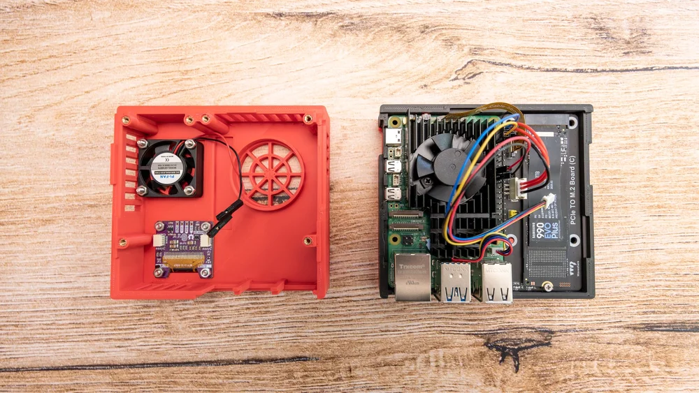  Zusammenbau der Little Backup Box, oberes Teil des Gehäuses mit Display und Lüfter, mittleres Teil mit Raspberry P i5 und Samsung NVMe M."2 SSD, Kabel sind angeschlossen. 