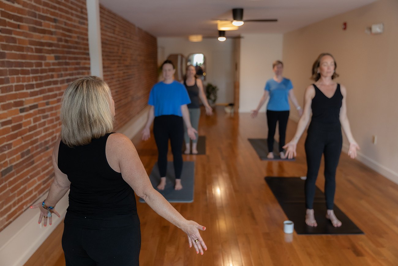 Instructor leading a traditional, non-heated yoga class at Sanctuary Yoga & Wellness in Exeter, NH.