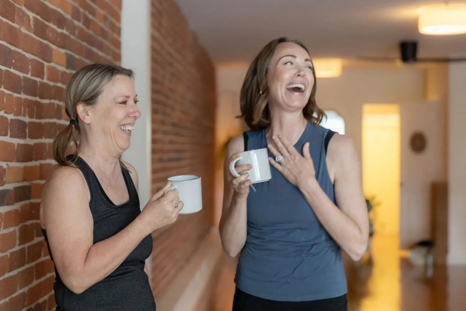 Two students connecting and sharing a moment of conversation at Sanctuary Yoga & Wellness in Exeter, NH.