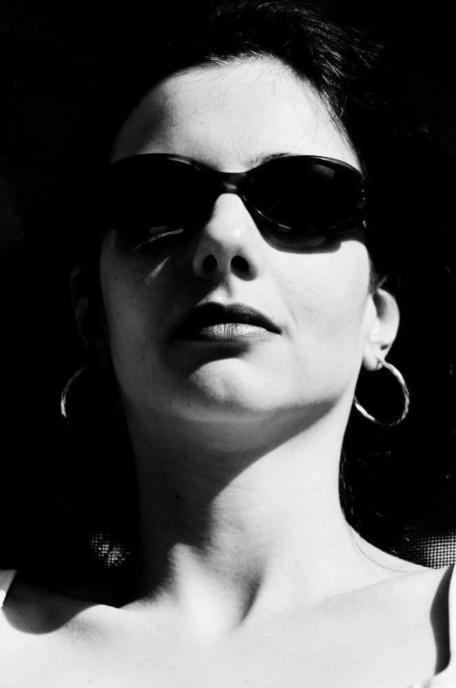 Fotografia fine art em preto e branco de mulher com óculos escuros — retrato de Alexandre Horta e Silva que combina luz, contraste e presença.