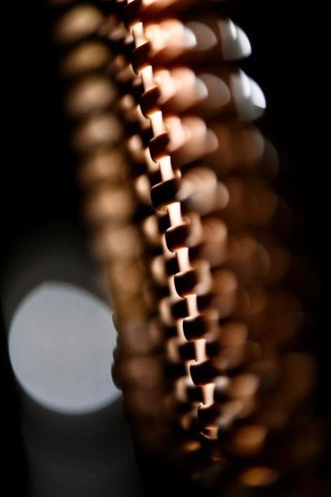 Fotografia fine art em close de estrutura metálica com luz dourada e fundo desfocado — arte abstrata de Alexandre Horta e Silva ideal para decoração moderna.