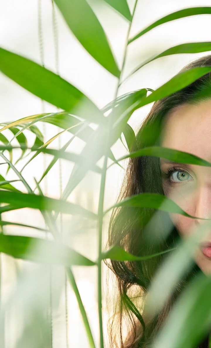 Fotografia fine art de olhar feminino através de folhas verdes — obra de Alexandre Horta e Silva que une natureza e presença humana.