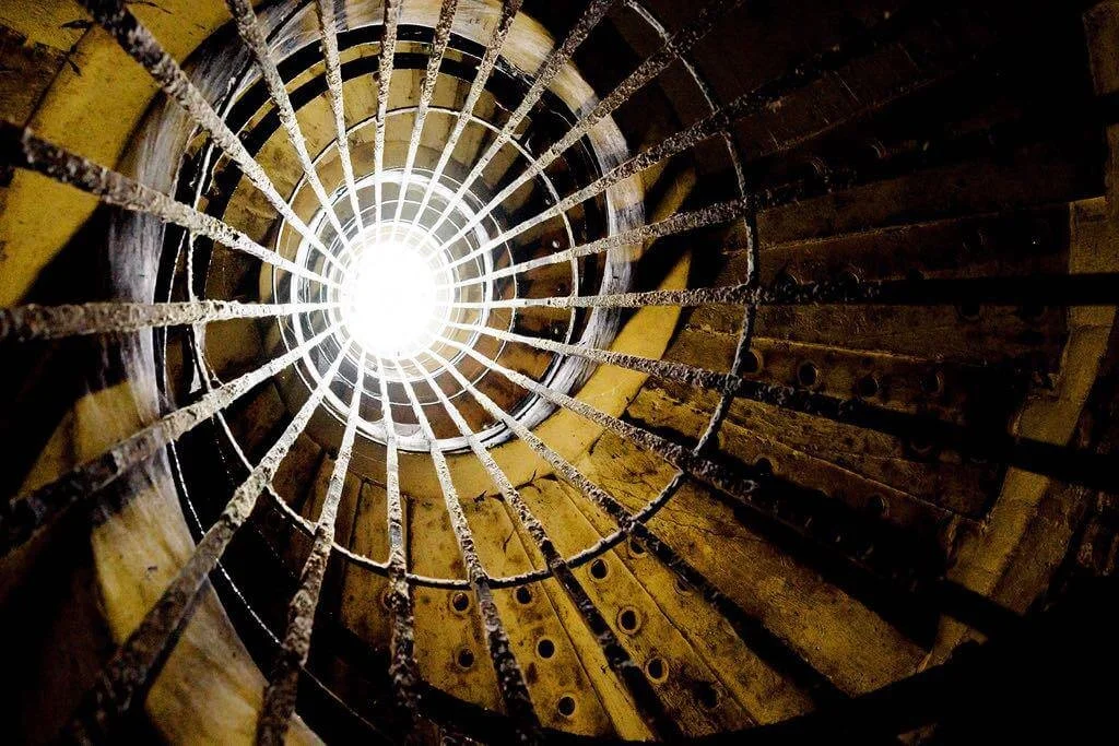 Fotografia fine art de estrutura circular metálica iluminada por luz central — obra de Alexandre Horta e Silva que explora forma, luz e perspectiva arquitetônica.