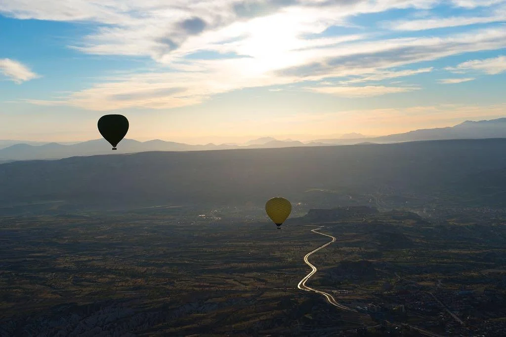 Fotografia fine art de um balão ao pôr do sol sobre montanhas e rio sinuoso — arte contemplativa de Alexandre Horta e Silva.