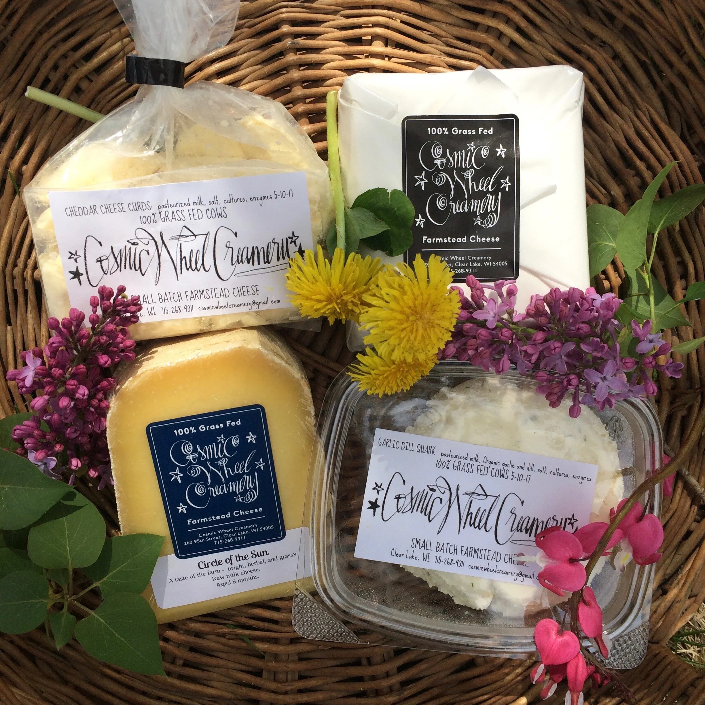 Various Cosmic Wheel Creamery cheese products laid out in a wicker basket.