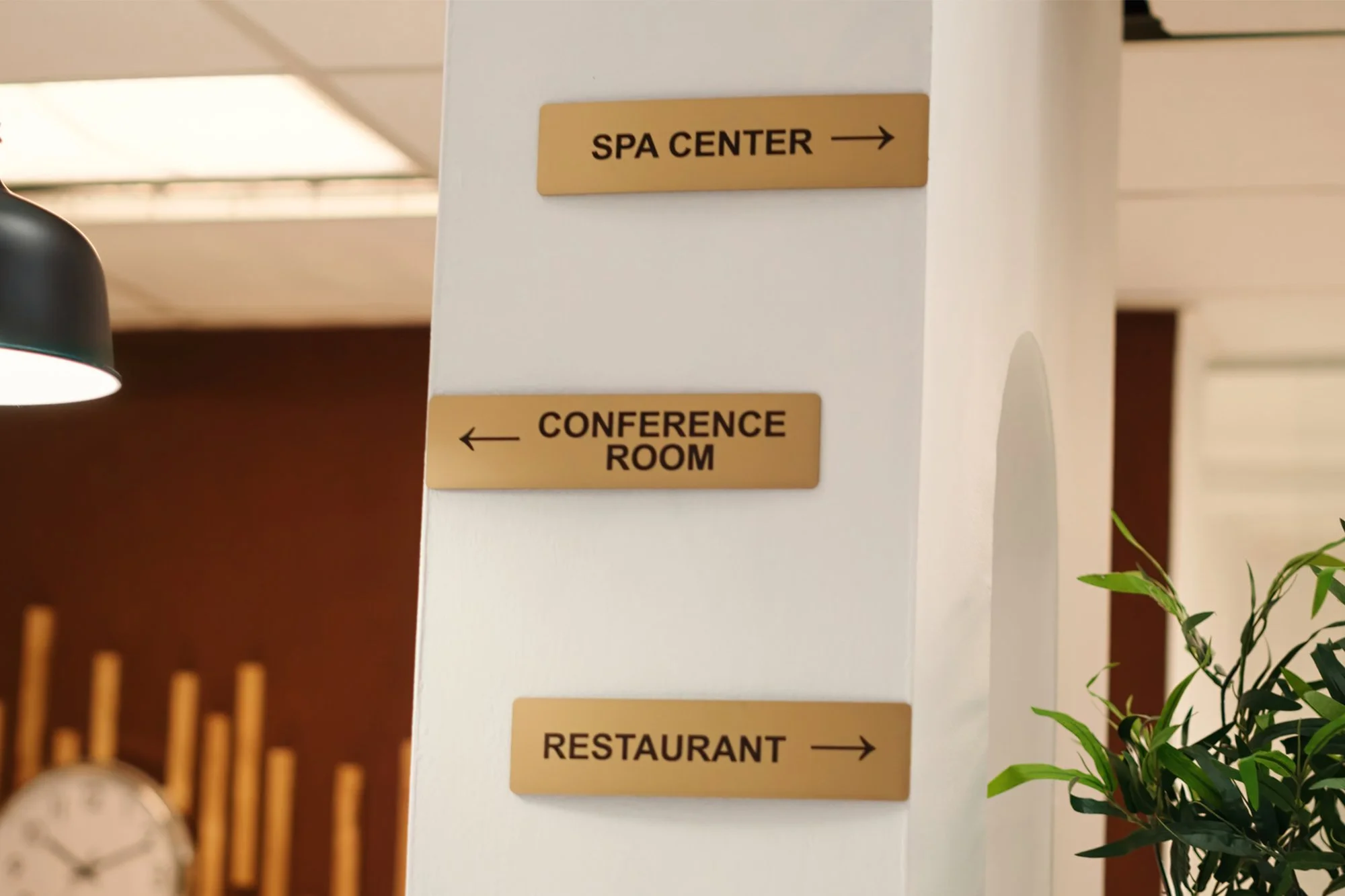 Directional signs on a white wall pointing to a spa center, conference room, and restaurant.