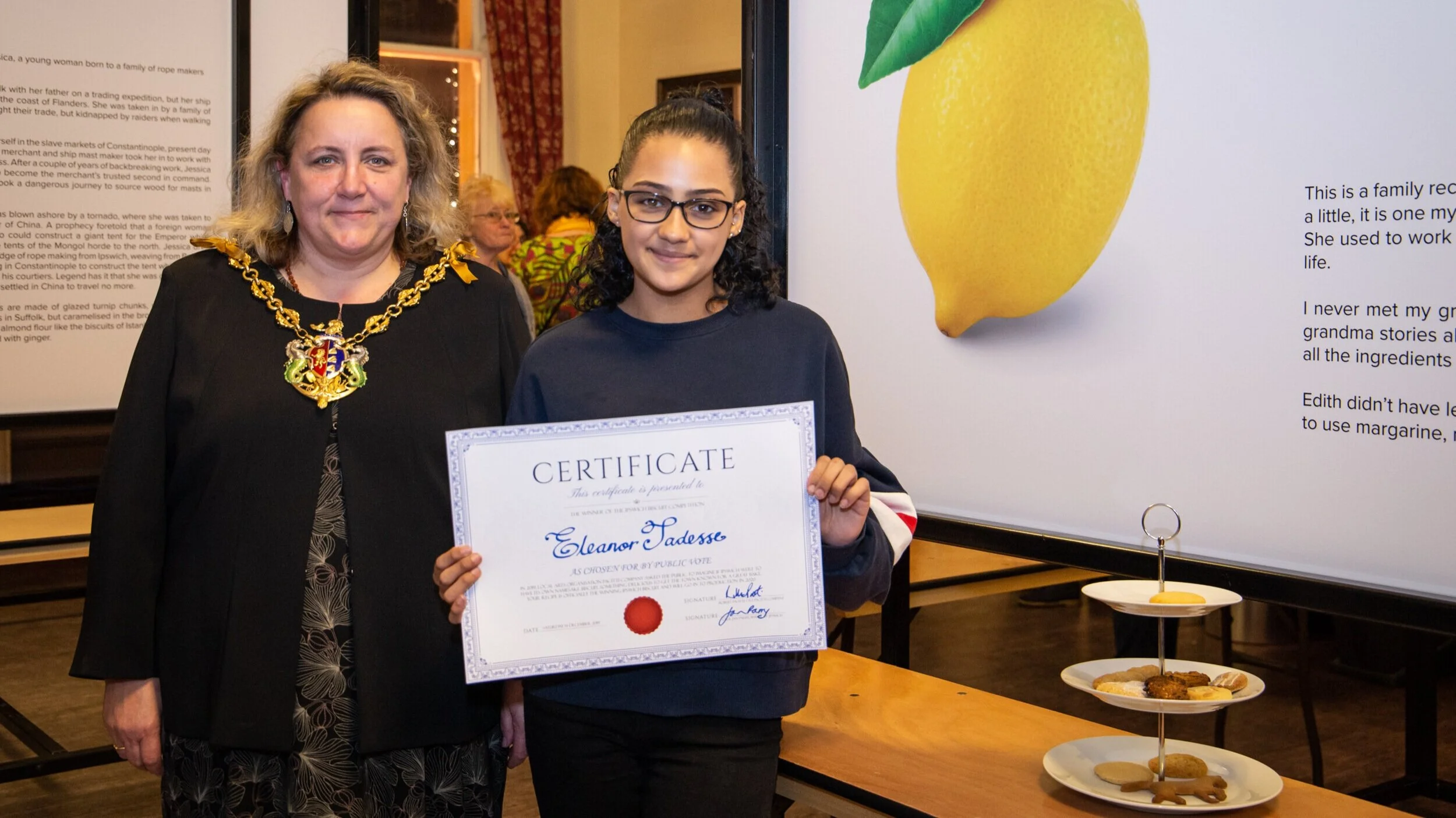 Councillor Jan Parry, Mayor of Ipswich, presents Eleanor Tadesse with a certificate for winning the Ipswich Biscuit Competition, along with a £100 cash prize (2019), photo by Louis Simpson