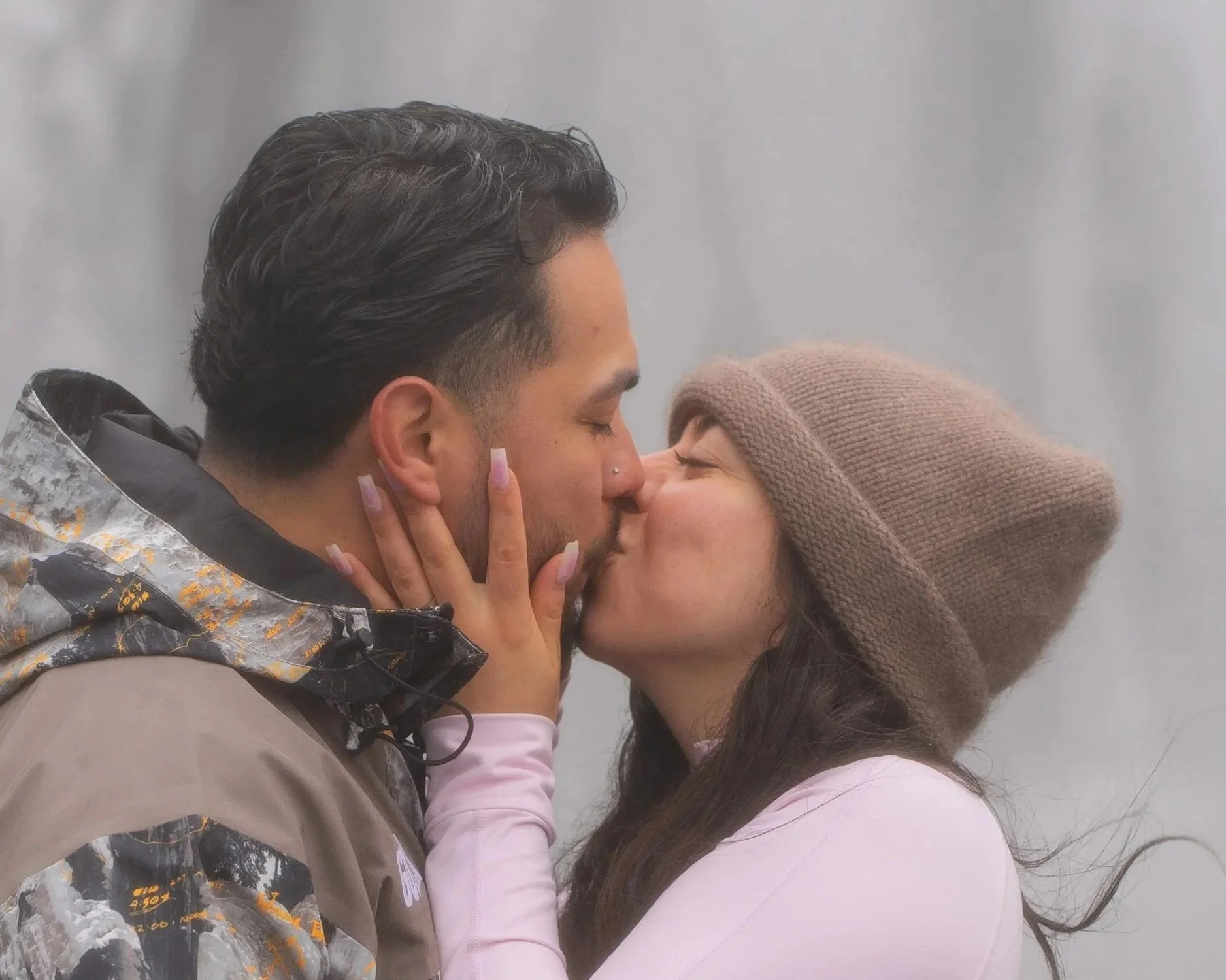 Kissing couple in front of Skogafoss waterfall in Iceland, during romantic Engagement,  Marriage Engagement, Engagement Iceland, Engagement Photographer, Surprise Engagement, Secret Engagement, Proposal, Proposal Iceland, Proposal Photographer, Surpr