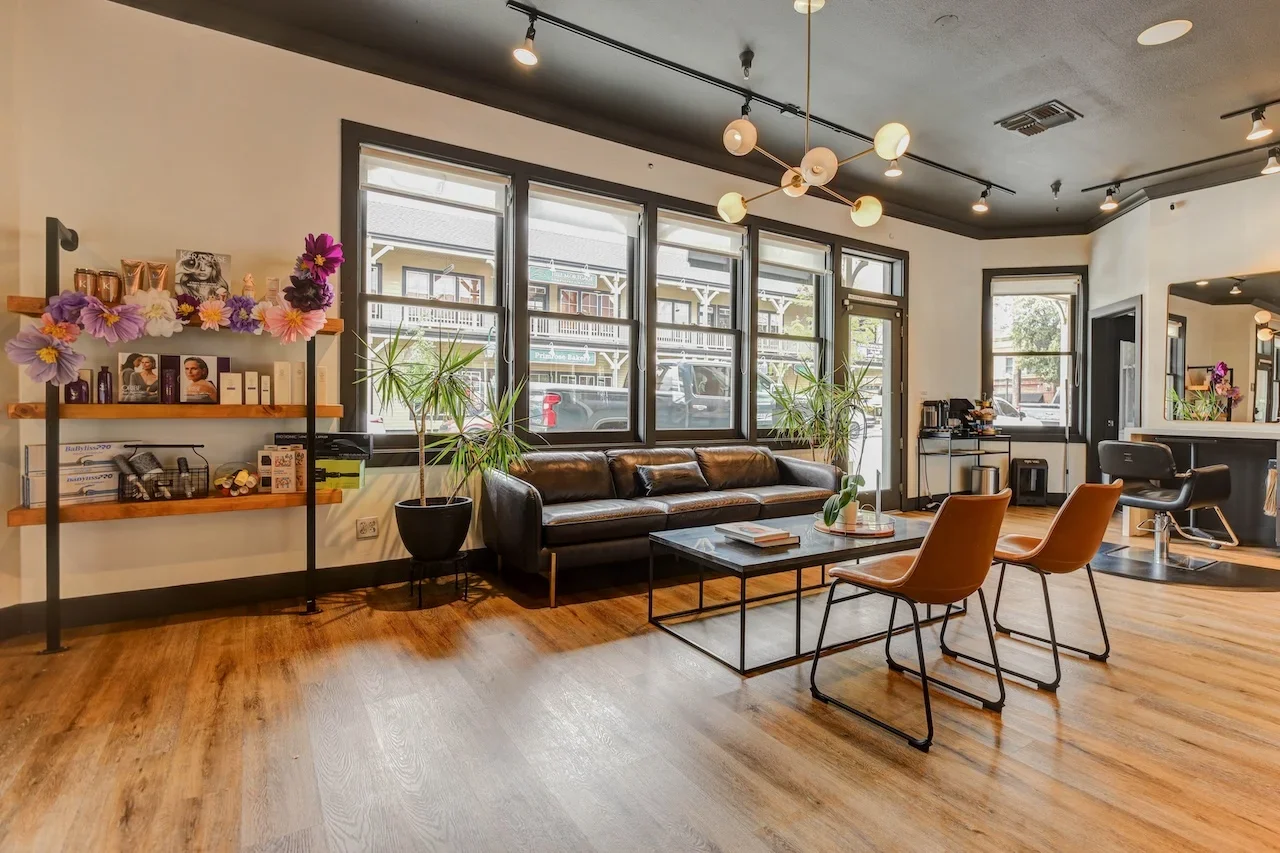 Theory Salon Pleasanton CA waiting area with modern decor, leather seating, and curated products, reflecting the salon’s warm and welcoming luxury atmosphere.