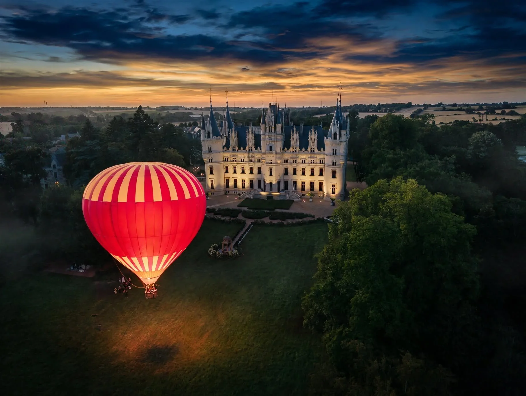 chateau challain with hot air baloon at sunset