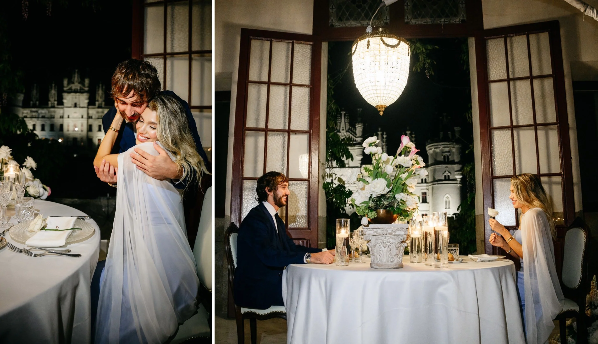 A wedding reception at night with a bride and groom seated at a table, surrounded by elegant decor including candles and flowers, with a large window and chandelier in the background.