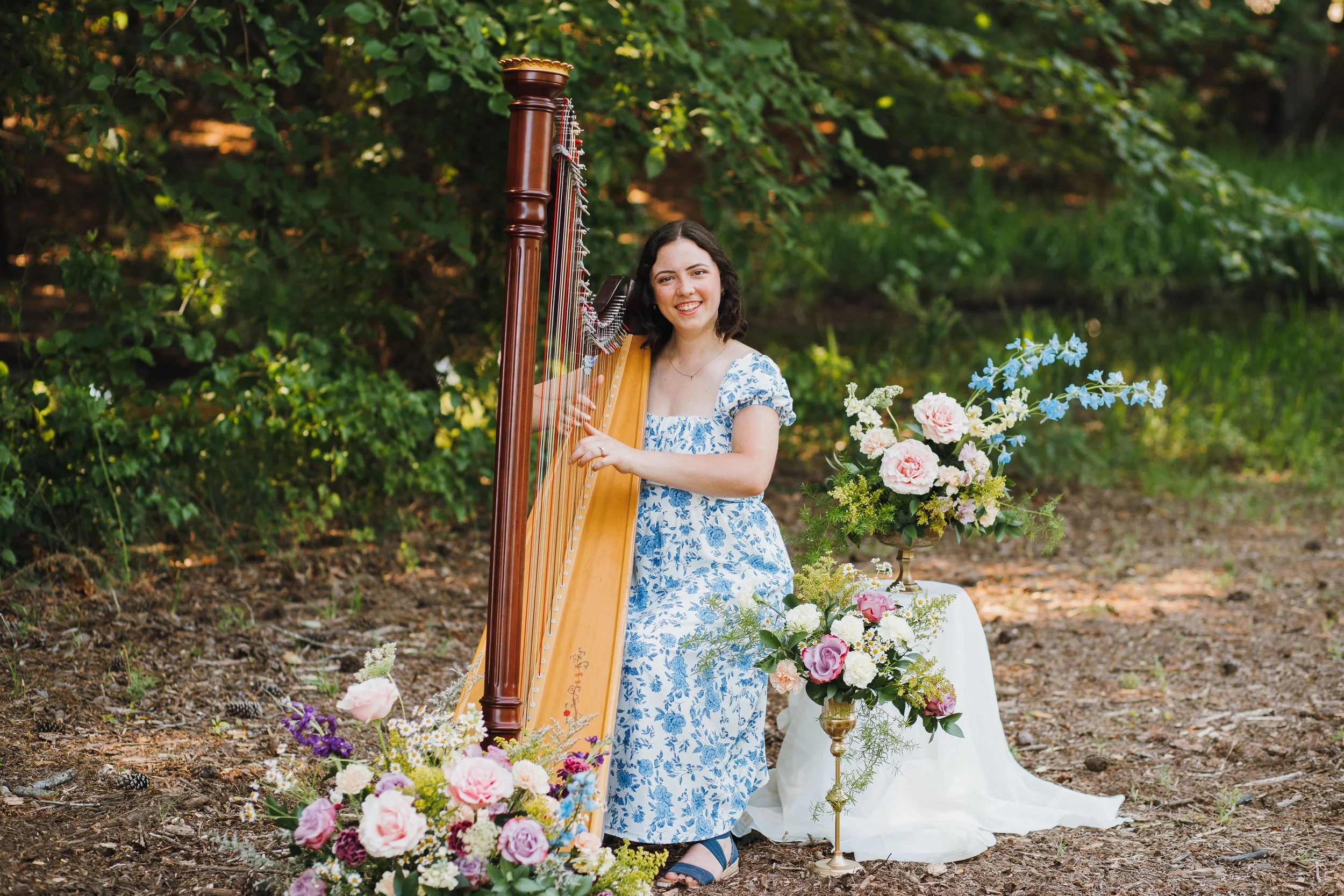 harpist surrounded by flowers on pedestals