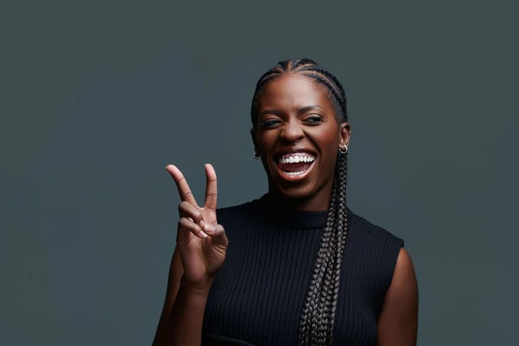 Portrait de Kipola Wakilongo, actrice et entrepreneure à Montréal, souriante et faisant un signe de paix, photographié par Montreal Headshot pour le magazine Souche