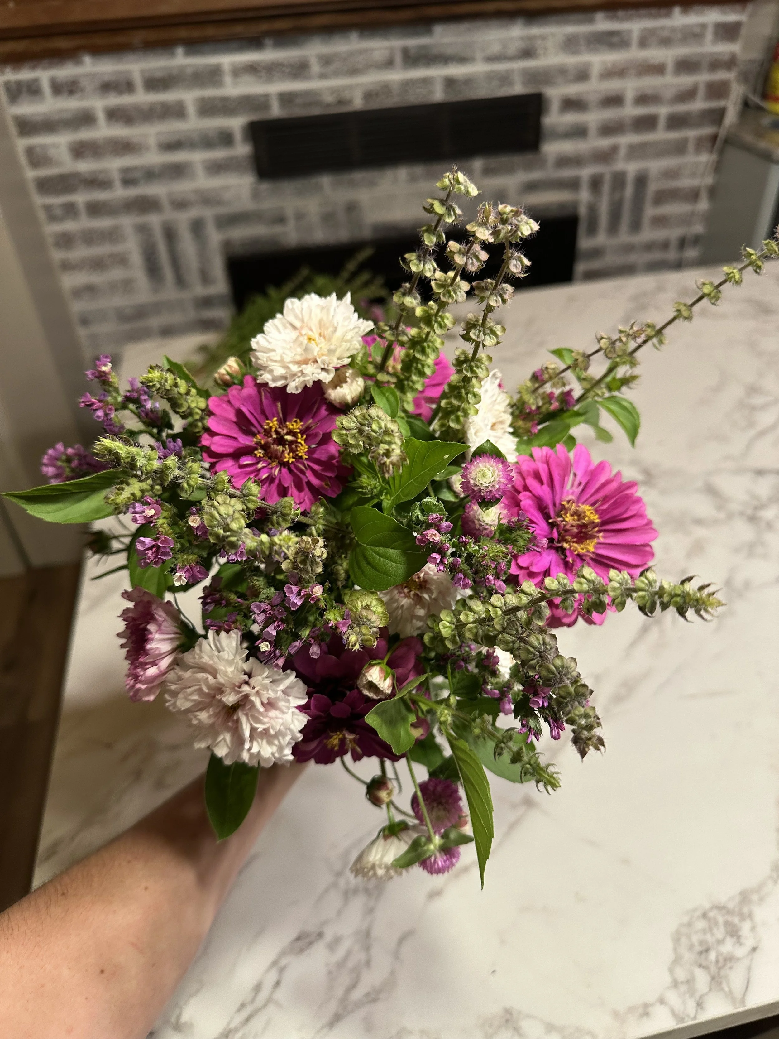 purple bouquet held up in front of countertop